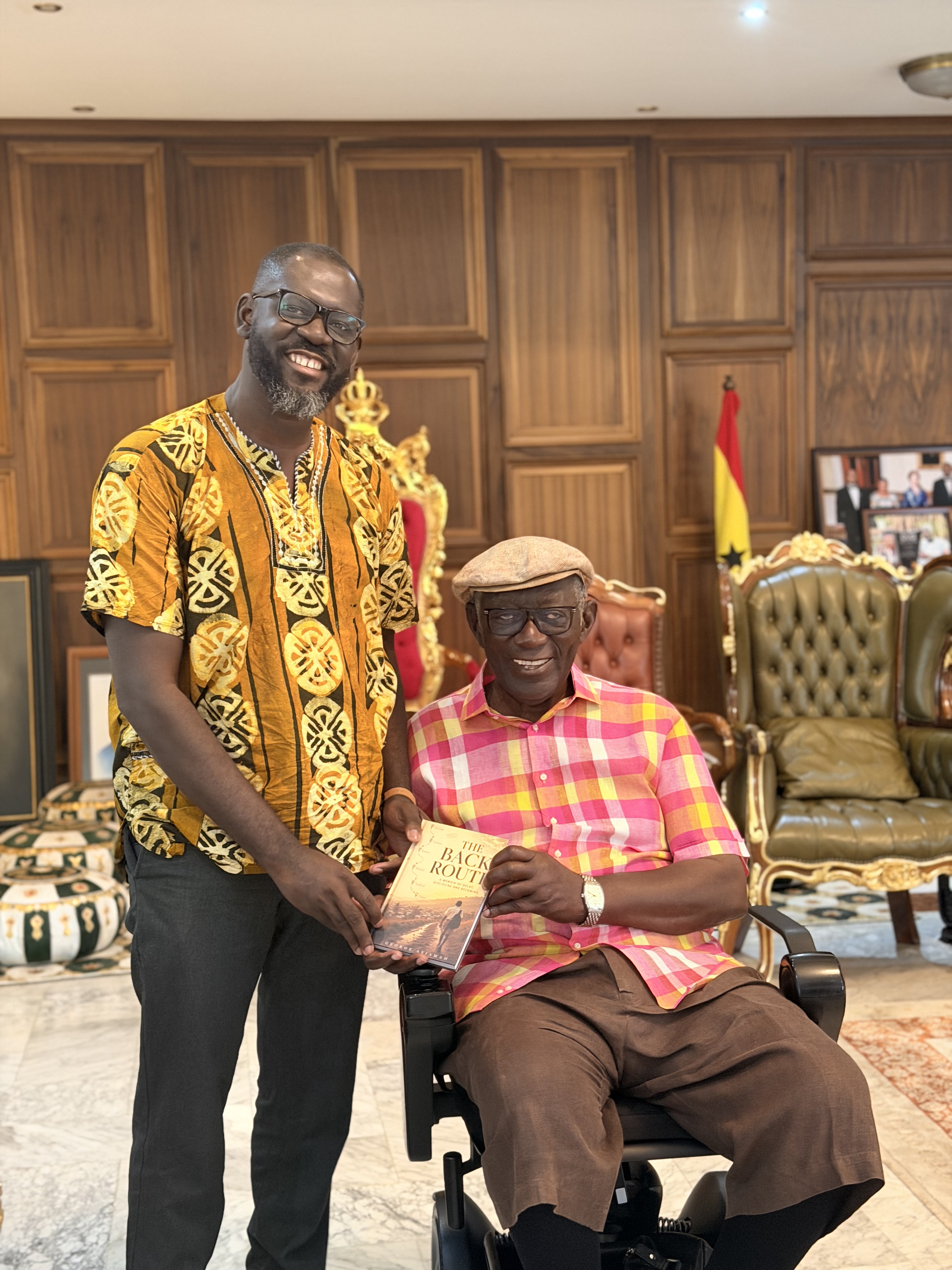 Dr George Asiamah presenting The Back Route to former President John Agyekum Kufuor
